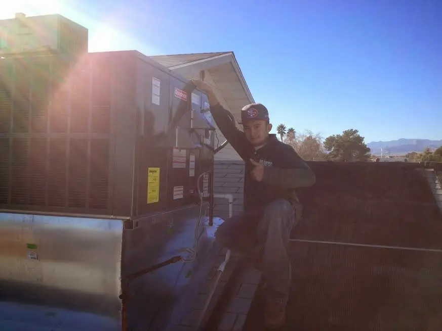 HVAC technician performing Air Duct Repair on a rooftop unit in Mims